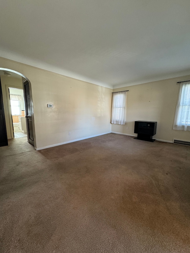 unfurnished living room featuring carpet and plenty of natural light