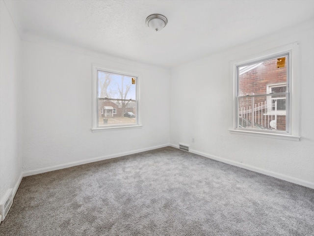 unfurnished room featuring carpet flooring and a textured ceiling