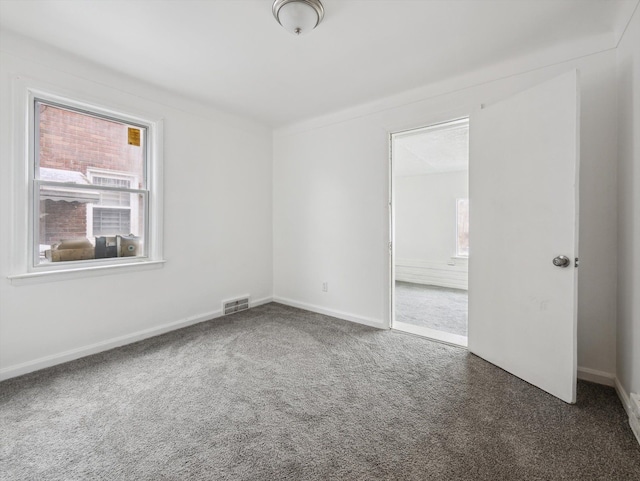 unfurnished room featuring dark colored carpet