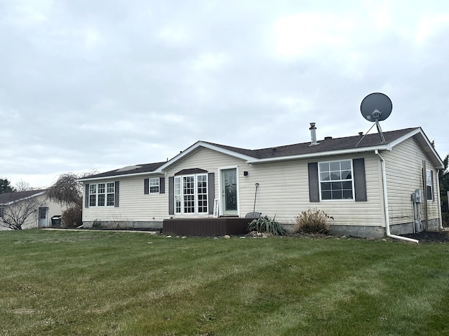 rear view of property featuring a lawn