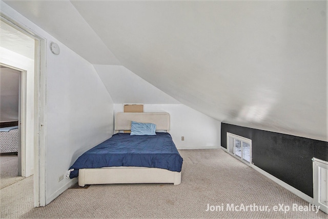 bedroom featuring baseboards, lofted ceiling, and carpet floors