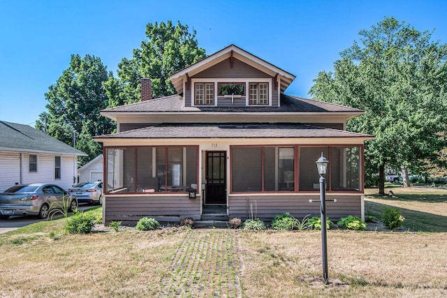 view of front of home featuring a front lawn and a sunroom