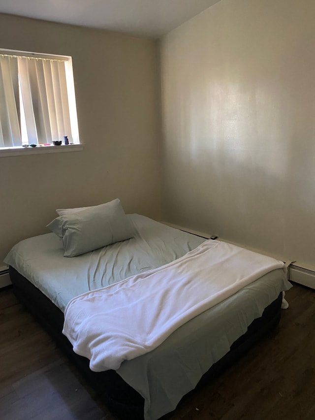 bedroom featuring baseboard heating and dark wood-type flooring