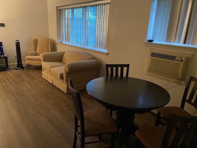 dining area with hardwood / wood-style flooring and an AC wall unit