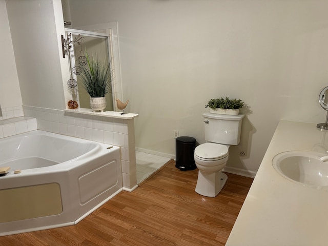 bathroom featuring vanity, hardwood / wood-style flooring, toilet, and a bathing tub