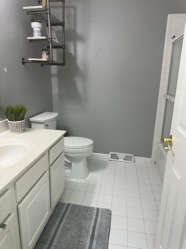 full bathroom featuring tile patterned flooring, vanity, toilet, and enclosed tub / shower combo