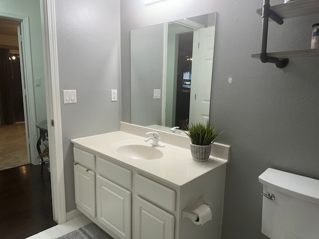 bathroom with tile patterned flooring, vanity, and toilet