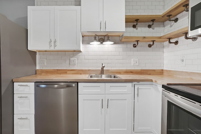 kitchen with backsplash, white cabinetry, wooden counters, and stainless steel dishwasher