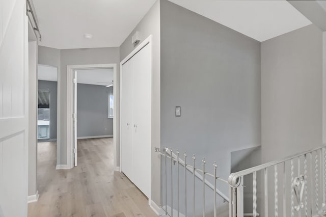 hallway with light hardwood / wood-style floors