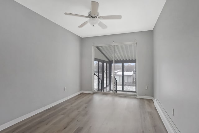 spare room with hardwood / wood-style floors, baseboard heating, and ceiling fan