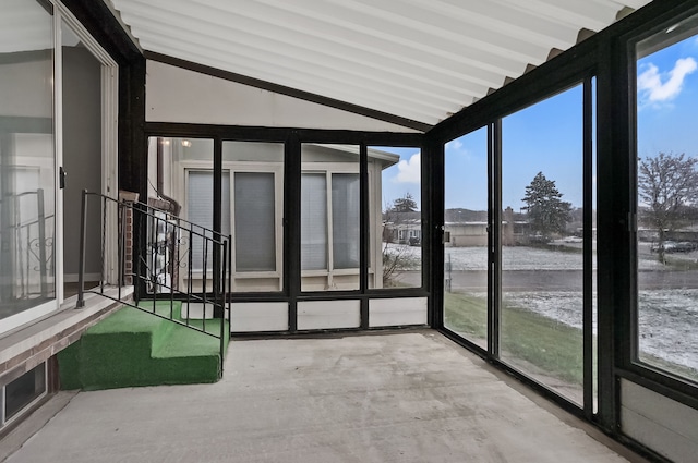 unfurnished sunroom featuring vaulted ceiling