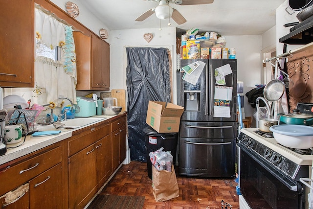 kitchen featuring black refrigerator with ice dispenser, dark parquet floors, sink, ceiling fan, and gas range gas stove