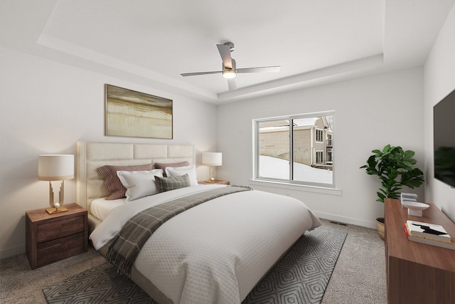 bedroom with carpet floors, a tray ceiling, and ceiling fan