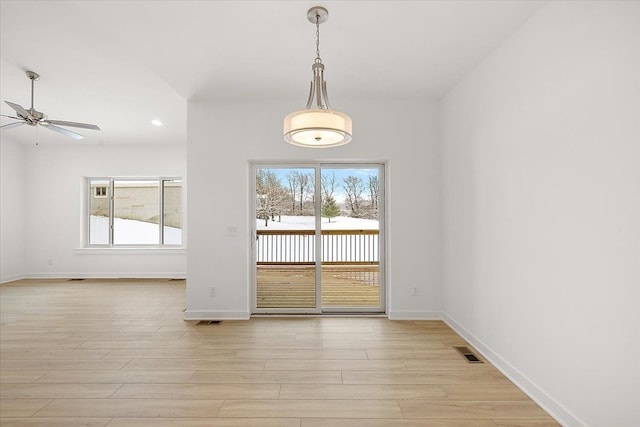 unfurnished dining area featuring light hardwood / wood-style floors and ceiling fan