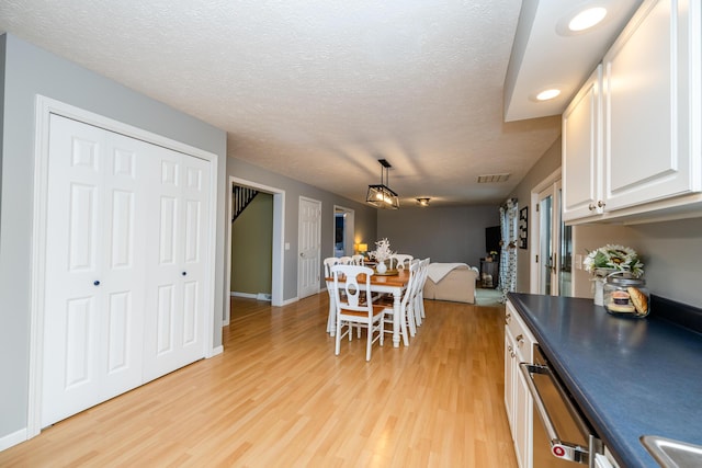 dining space featuring light hardwood / wood-style flooring and a textured ceiling