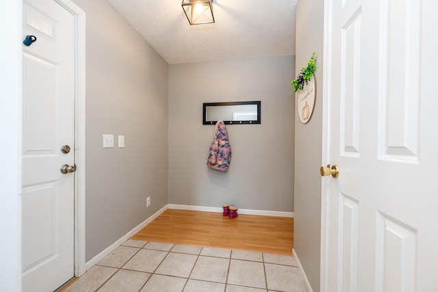 doorway featuring light tile patterned flooring and a textured ceiling