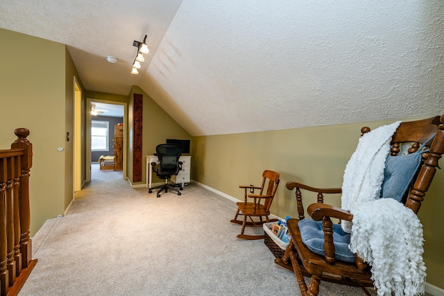 sitting room with a textured ceiling, light carpet, and vaulted ceiling