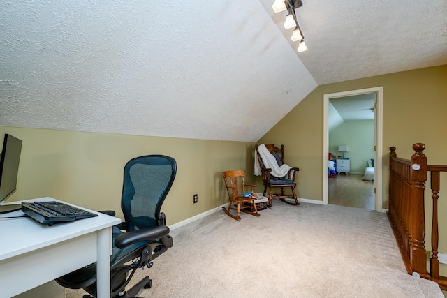 home office featuring carpet, a textured ceiling, and vaulted ceiling