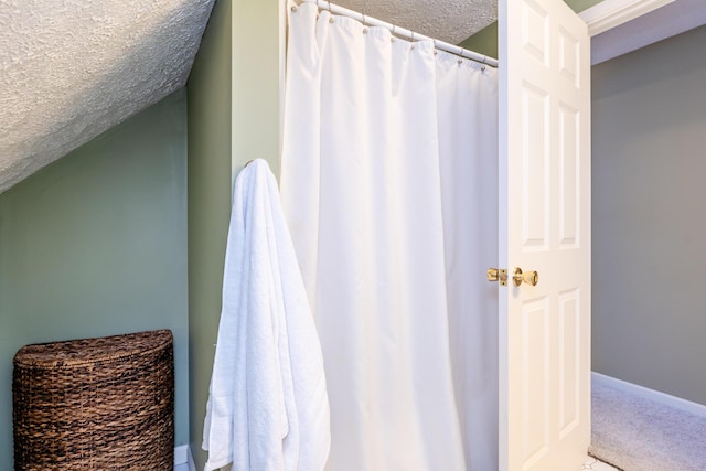 bathroom with a textured ceiling and lofted ceiling