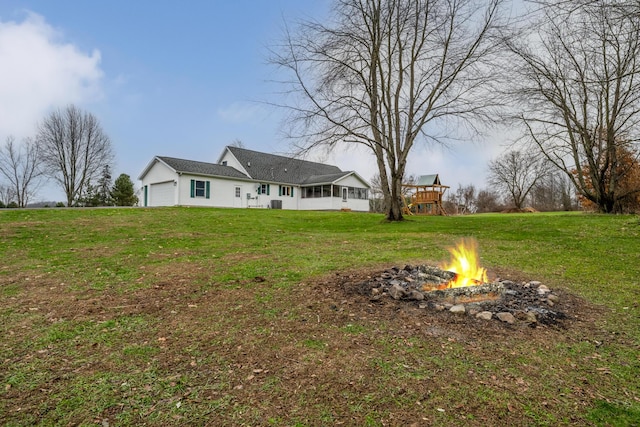 view of yard with an outdoor fire pit and a garage