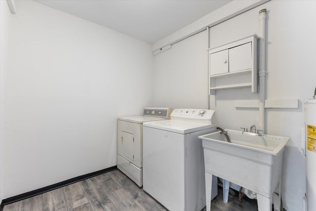 laundry area featuring separate washer and dryer, sink, and dark hardwood / wood-style floors