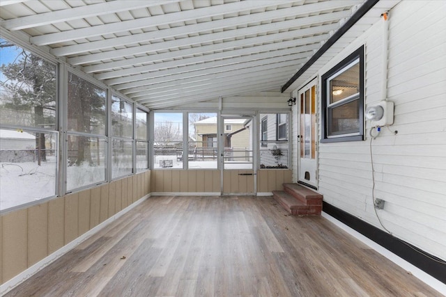 unfurnished sunroom featuring vaulted ceiling