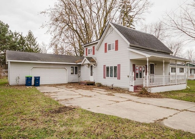 view of front of home featuring covered porch, a garage, and a front lawn