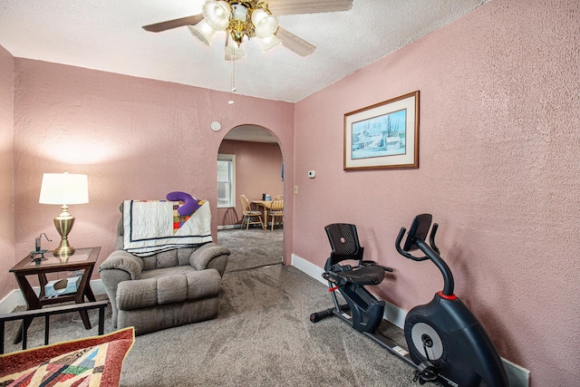 exercise room featuring carpet flooring, a textured ceiling, and ceiling fan