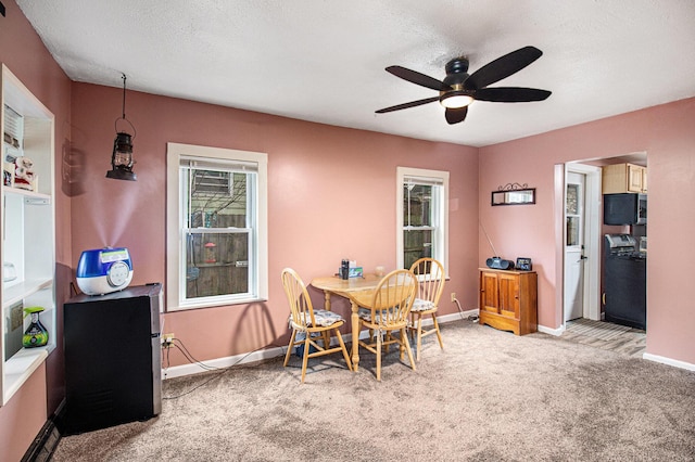 dining room with light carpet, a textured ceiling, and ceiling fan