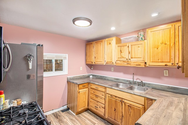 kitchen with stainless steel fridge, light hardwood / wood-style floors, and sink