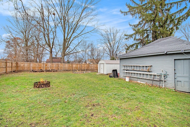 view of yard featuring a storage shed and an outdoor fire pit