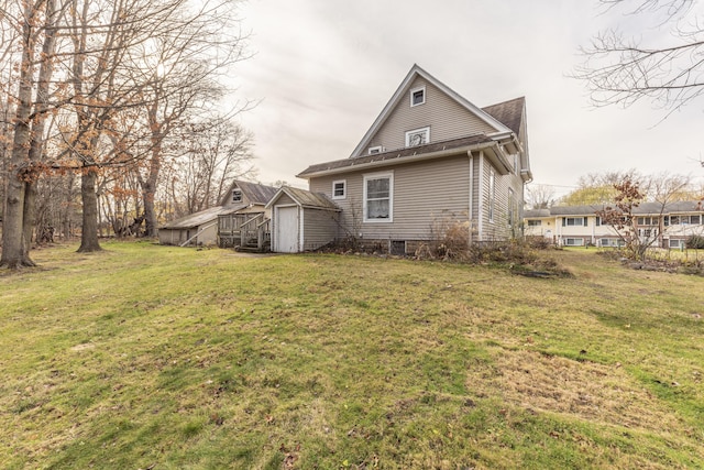 rear view of house with a yard and a storage shed