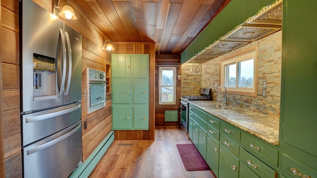 kitchen with appliances with stainless steel finishes, sink, wood walls, and wood ceiling