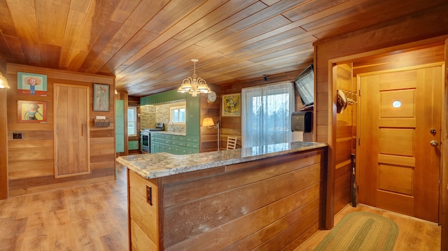 kitchen with light stone countertops, wood ceiling, wooden walls, decorative light fixtures, and an inviting chandelier