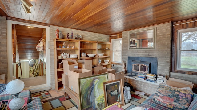 living room with plenty of natural light, wood ceiling, a fireplace, and brick wall