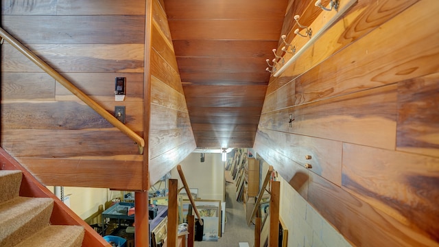 staircase featuring wooden walls