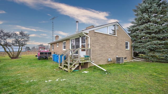 back of house with a lawn and central AC