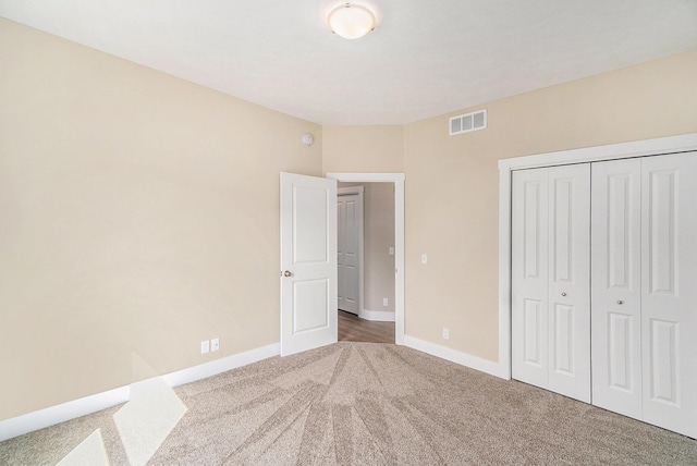 unfurnished bedroom featuring carpet floors and a closet