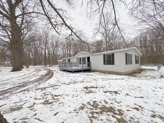 view of snowy exterior with a wooden deck