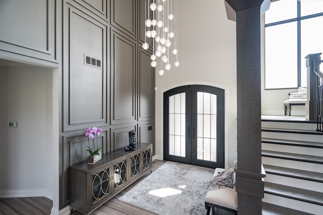 foyer entrance featuring french doors, hardwood / wood-style flooring, and a healthy amount of sunlight