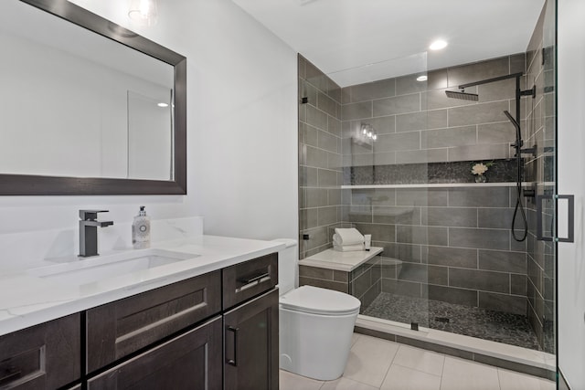 bathroom with tile patterned floors, vanity, an enclosed shower, and toilet