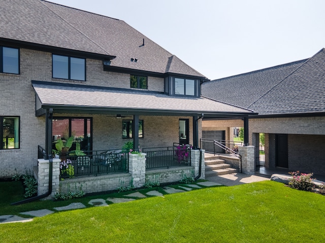 rear view of house with covered porch and a yard