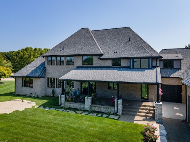 view of front of property featuring a garage, covered porch, and a front yard