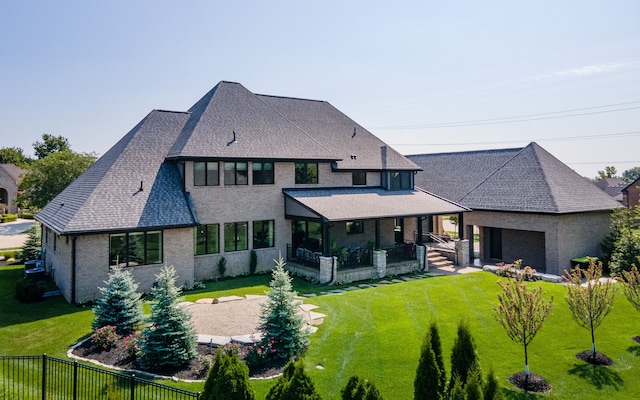 rear view of property featuring a lawn