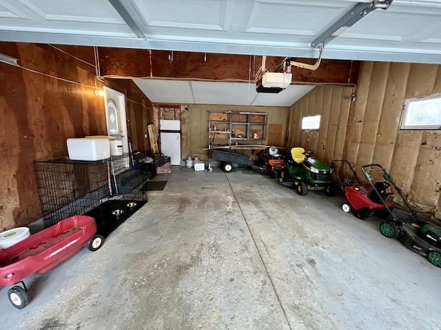 garage featuring wooden walls and a garage door opener