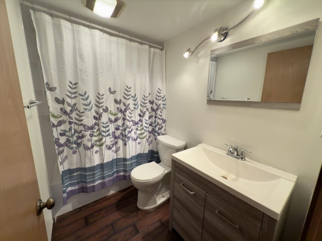 full bathroom featuring toilet, vanity, shower / tub combo, and hardwood / wood-style floors