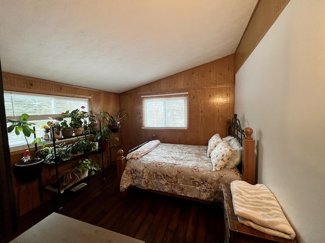 bedroom with wood walls, dark hardwood / wood-style floors, and lofted ceiling