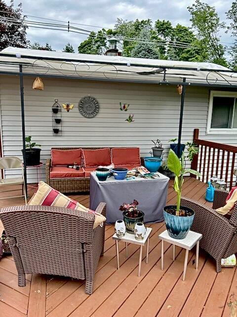 wooden terrace with an outdoor living space