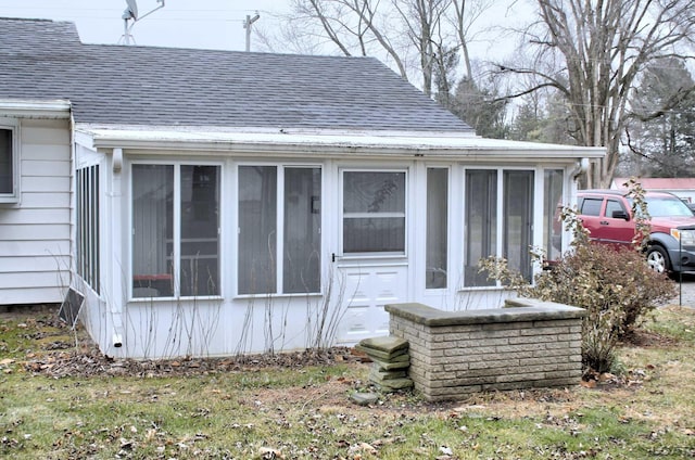 exterior space with a downspout, gutters, and roof with shingles