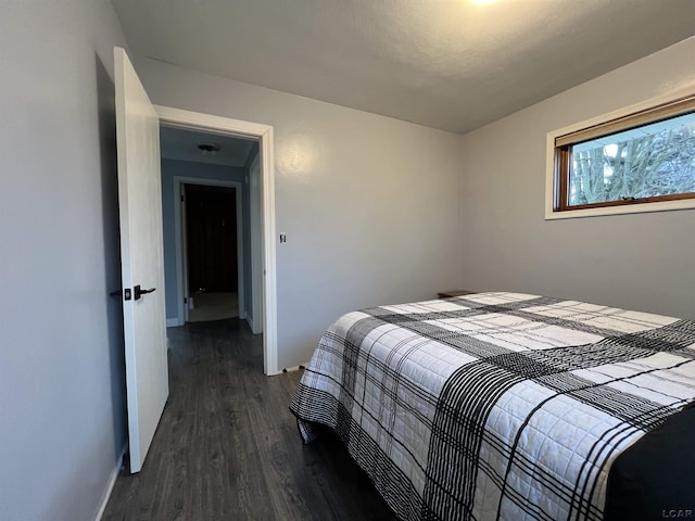 bedroom with dark hardwood / wood-style floors